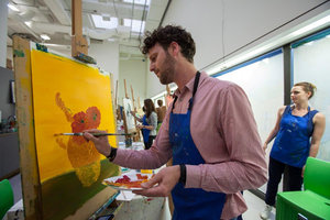 Een bezoeker tijdens een schilderworkshop