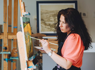 Een vrouw is aan het schilderen tijdens een workshop in het Van Gogh Museum. Foto: Jelle Draper